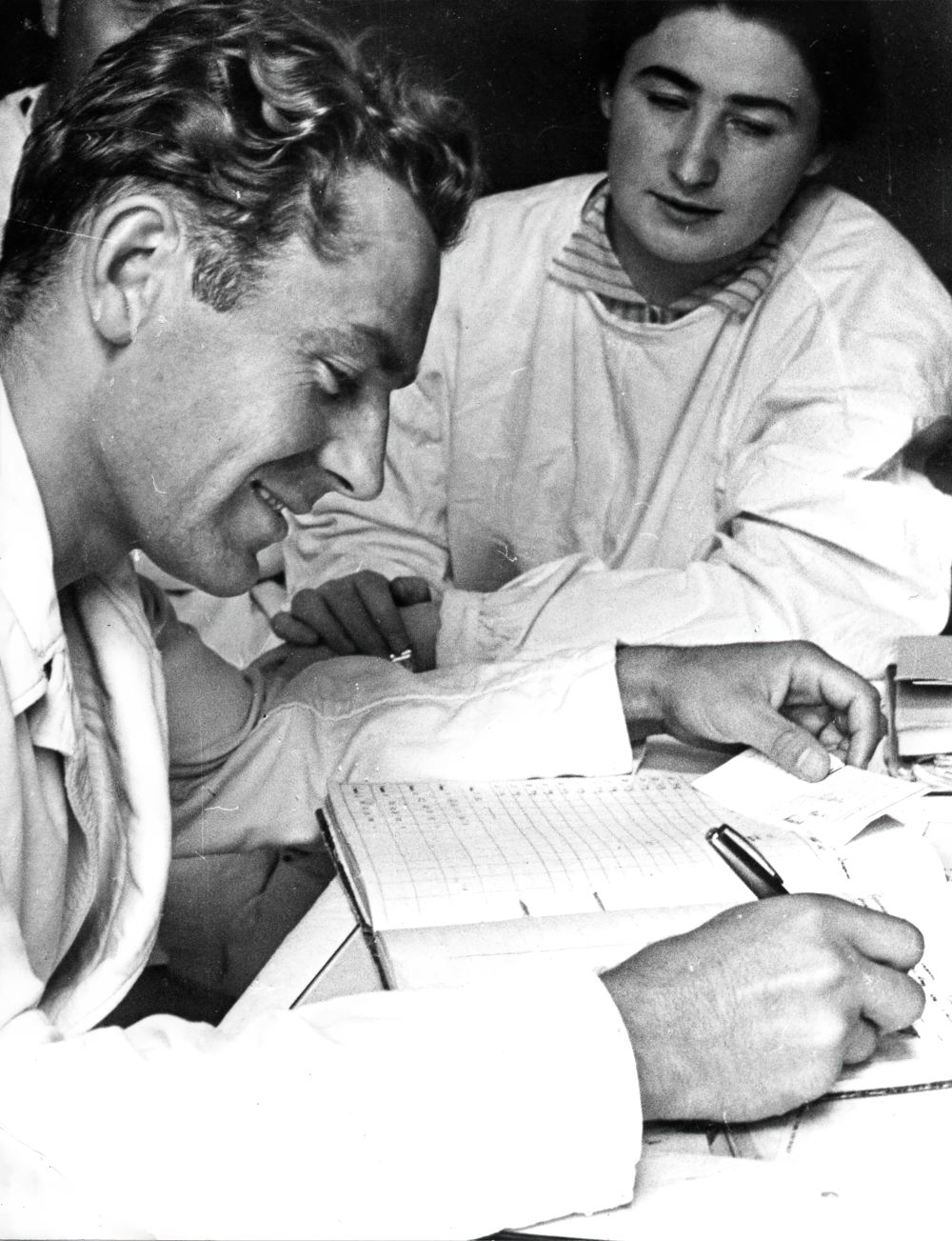 Г.С. Титов после вращения на центрифуге записывает в журнал отчёт о своих ощущениях. Наблюдение за испытуемым ведёт А.Р. Котовская.