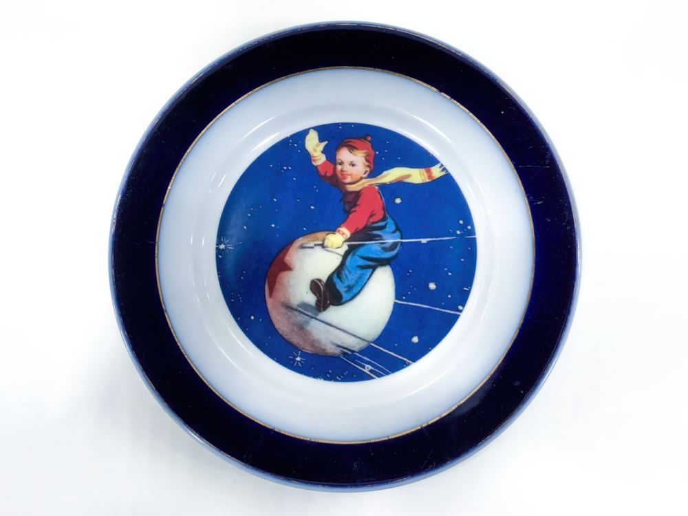 Тарелка "С новым годом!" (мальчик на спутнике). 1957-1965 гг. Фаянс, деколь, обжиг, заводское производство. СССР, РСФСР, Московская область, Талдомский район, посёлок Вербилки Тарелка "С новым годом!" (мальчик на спутнике). 1957-1965 гг. Фаянс, деколь, обжиг, заводское производство. СССР, РСФСР, Московская область, Талдомский район, посёлок Вербилки