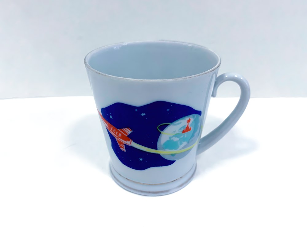 Кружка «Полет в космос». 1960-е гг. Фарфор, заводское производство СССР, РСФСР, г. Ленинград, Ленинградский фарфоровый завод Кружка «Полет в космос». 1960-е гг. Фарфор, заводское производство СССР, РСФСР, г. Ленинград, Ленинградский фарфоровый завод